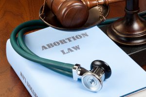 "Concept shot. Gavel, stethoscope and scale of justice next to Abortion Law book."